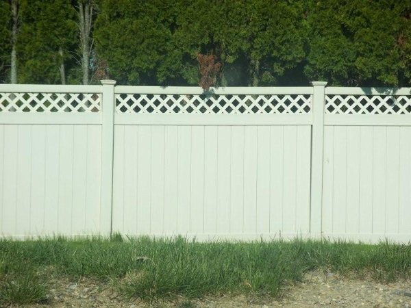 Tan vinyl privacy fence with lattice top installed by Armitage Fence